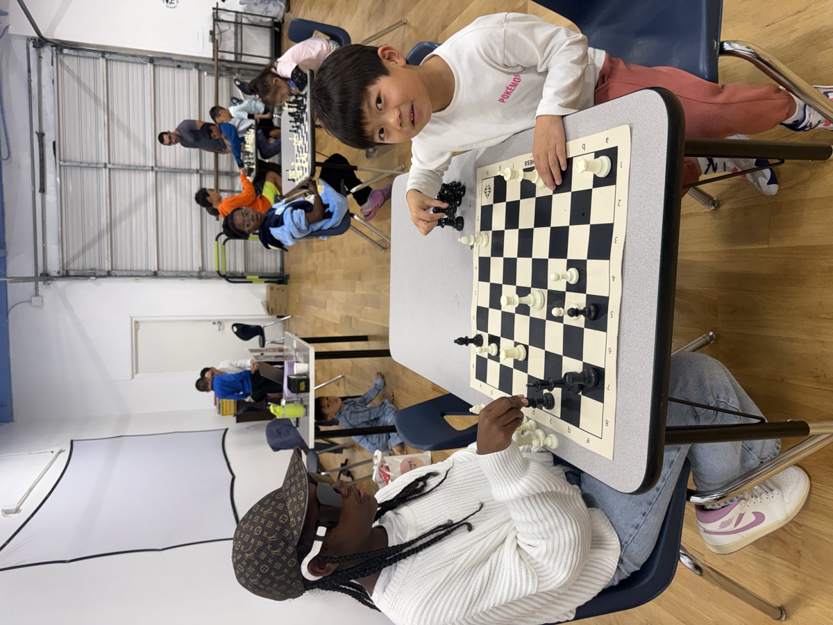 A coach playing chess with a young student