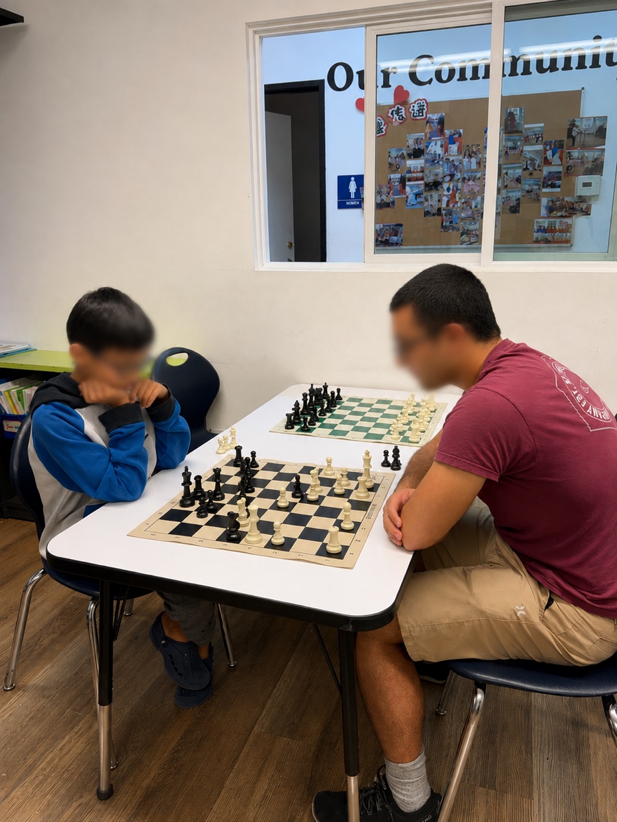 A coach working with a student in front of the community board