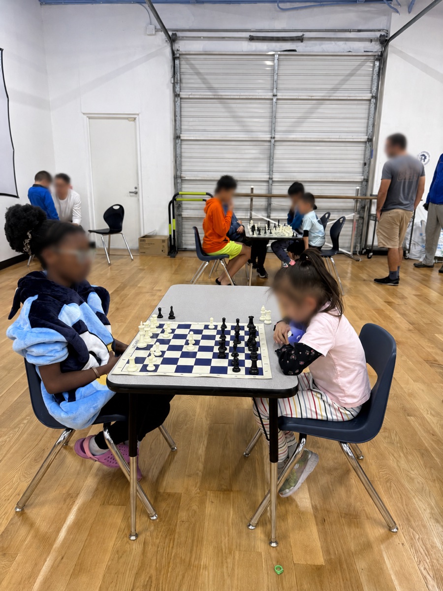 A group of students gathered around a chess board