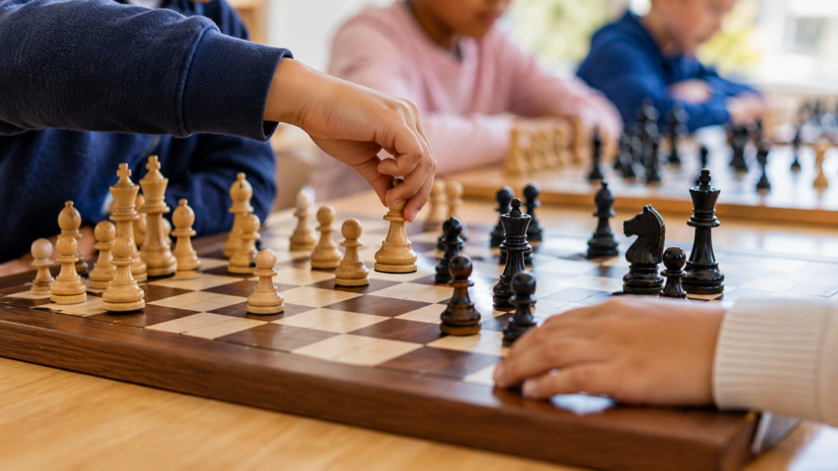 Kids moving chess pieces during a lesson